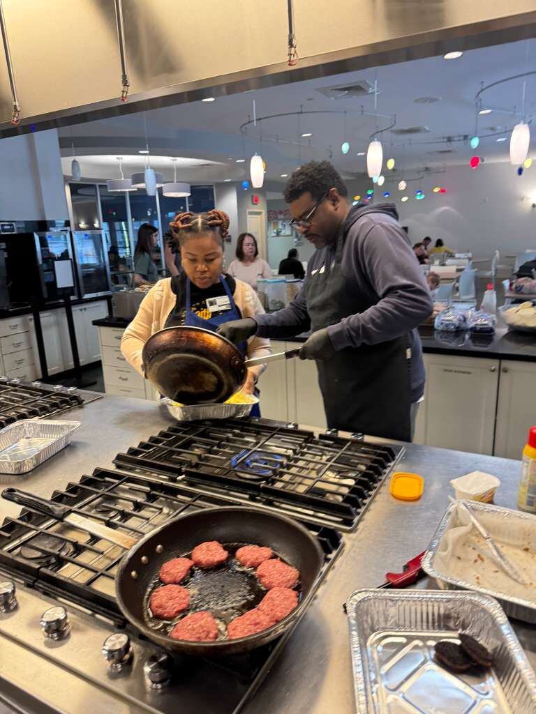 ACF Dallas volunteers cooking at a commercial stove